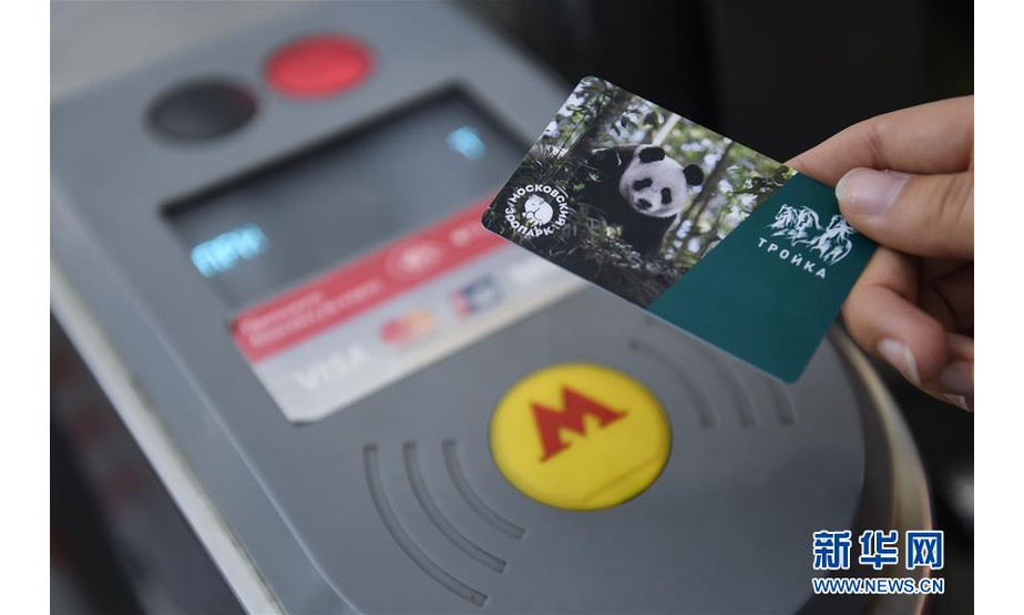7月10日，在俄罗斯莫斯科，一名乘客购买莫斯科地铁发行的印有中国大熊猫形象的交通卡。 近日，莫斯科地铁开始发售印有中国大熊猫形象的交通卡，纪念莫斯科动物园建园155周年和今年4月中国大熊猫“如意”和“丁丁”入住该园。这批限量版交通卡发行量为1万张。