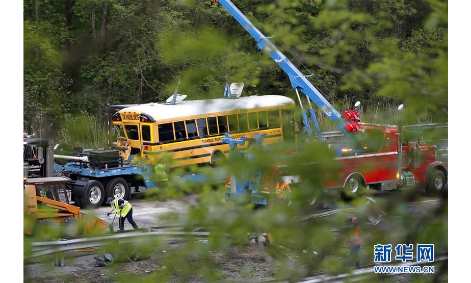 5月17日，在美国新泽西州莫里斯县，工作人员在校车与卡车相撞事故现场工作。美国新泽西州州长墨菲17日说，该州当天发生一起校车与卡车相撞事故，事故造成至少一名教师和一名学生死亡，另有43人受伤。新华社记者李木子 摄