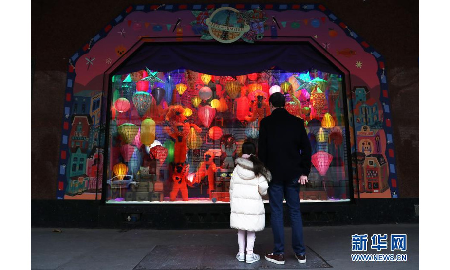 11月22日，一对父女在法国巴黎老佛爷百货商店的圣诞橱窗前驻足欣赏。新华社记者 高静 摄