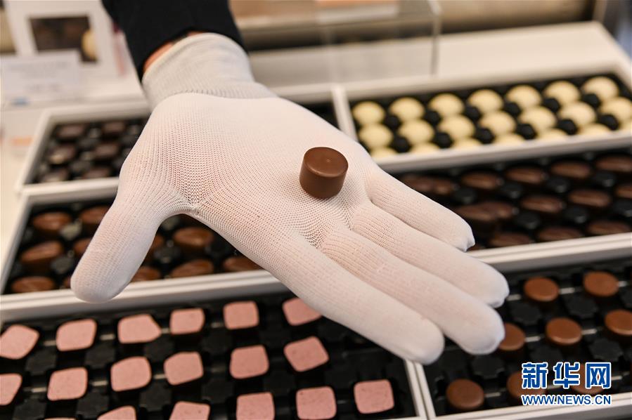 9月5日，一名店员在比利时布鲁塞尔一家商店展示巧克力甜品。新华社发（里卡多·帕雷贾尼摄）