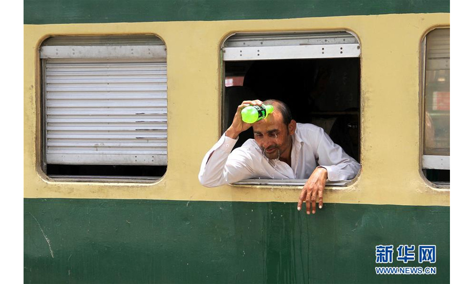 5月22日，在巴基斯坦卡拉奇，一名男子给自己浇水降温。近日，巴基斯坦南部城市卡拉奇连遇高温天气，最高气温达44摄氏度，已造成至少65人死亡。新华社发