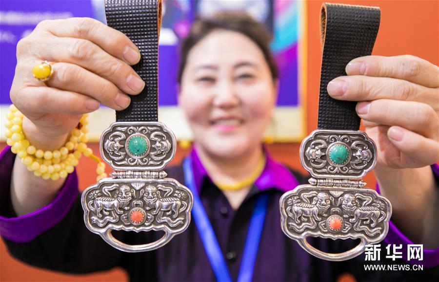 1月14日，非遗传承人苏格尔在非遗年货展上展示蒙古族腰带佩饰。新华社发（丁根厚 摄）