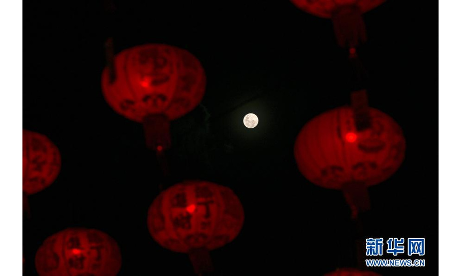 这是2月26日在马来西亚吉隆坡拍摄的大红灯笼映衬下的元宵节圆月。

　　当日是元宵佳节。新华社发（张纹综摄）