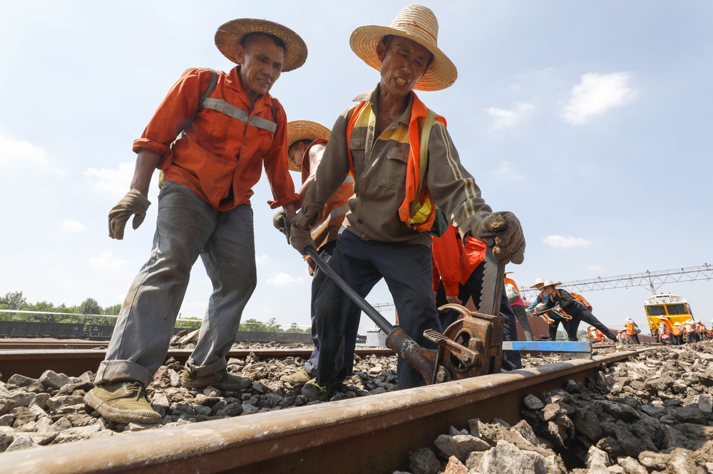 8月4日，鹰潭工务机械段的工作人员在江西鹰潭铁路枢纽编组站施工作业。