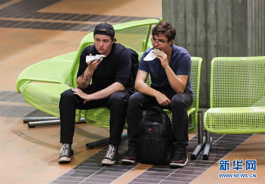 9月11日，在德国首都柏林，两名男子品尝可丽饼。新华社记者 单宇琦 摄