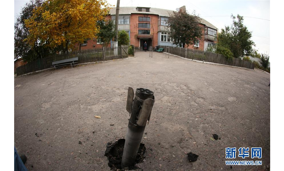 10月9日，在乌克兰切尔尼戈夫州伊奇尼亚市附近，一枚弹药残骸嵌入路面。 乌克兰国防部9日说，北部切尔尼戈夫州伊奇尼亚市附近当天凌晨发生的军火库爆炸未造成人员伤亡。事发后，附近38个居民点近1.2万人被疏散。 新华社发（谢尔盖摄）
