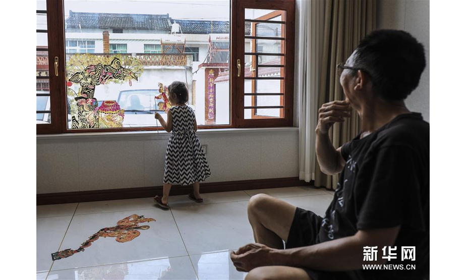 8月1日，皮影艺人蔡善存在家中与小孙女玩皮影。新华社记者 兰红光 摄