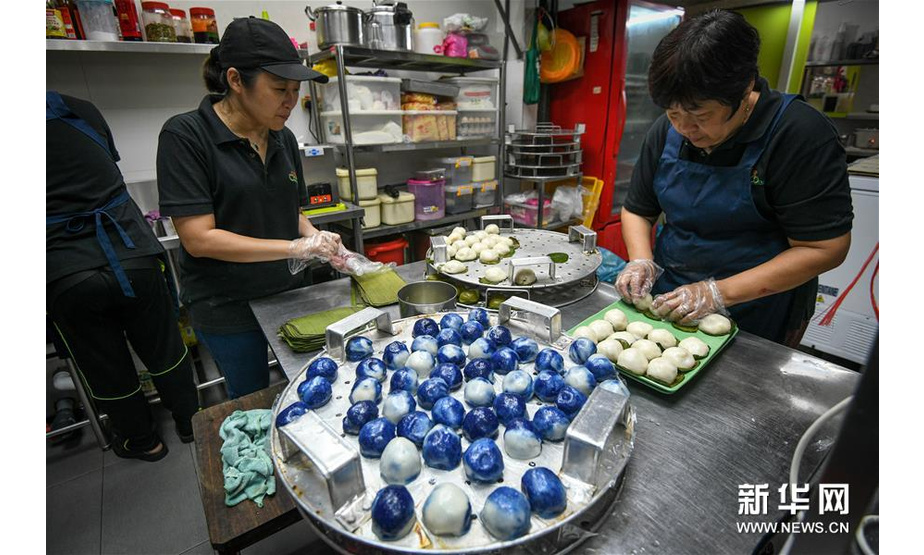 9月1日，在马来西亚吉隆坡，郑桂玲（左）和母亲姚秀蓝在自己的餐厅内制作娘惹糕。 9月13日，中国将迎来传统佳节——中秋节。月饼作为中秋节的传统糕点，久负盛名，备受人们喜爱。那么世界上的其他地区是否也有自己独特的传统糕点，让人食之难忘呢？答案是肯定的。 在马来西亚，早期的中国移民与当地人的后代被称为峇峇娘惹，男性称峇峇，女性叫娘惹，是东南亚土生华人族群。峇峇娘惹保留了中华传统习俗，同时也吸收了当地马来人的文化，他们的美食同样兼具了中马两国的特色，娘惹糕是其中的代表之一。娘惹糕由糯米、椰浆、香料等原料制成，口感软糯，种类及口味繁多。糕点取用蝶豆花、班兰叶等植物的汁液上色，形成艳丽的色彩，是备受当地人欢迎的美食。 新华社发（张纹综摄）