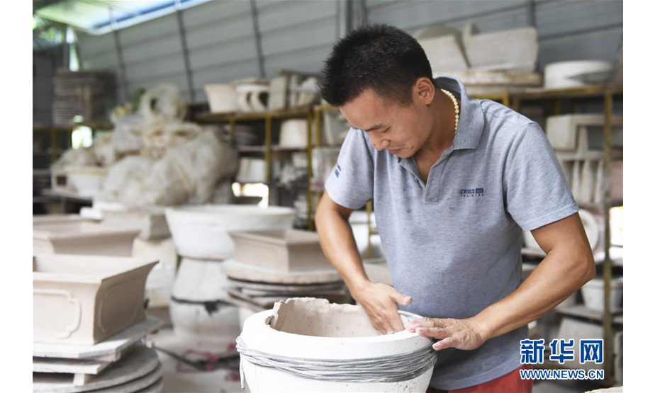 赵勇在自己创办的陶瓷制品加工厂内将泥坯放进模具里（8月11日摄）。 新华社记者 曹祎铭 摄
