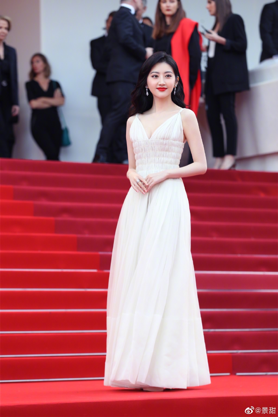 景甜在社交平台上晒出一组戛纳美照，只见她身穿纯白色吊带深V长裙，大秀性感身材。一头长卷发温柔披肩，妆容精致抹红唇气场十足。