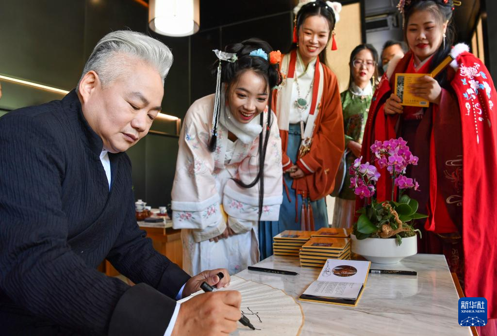 12月1日，《古音峥嵘》第四辑“天籁古音，曲韵悠悠”音乐MV拍摄在广州从化一景区进行。国乐大师方锦龙以阮、簧、尺八等乐器，奏响广东音乐，用新视角呈现粤语粤韵。图为12月1日，国乐大师方锦龙（左）在广州为国乐乐迷签名送唱片。新华社记者 刘大伟 摄