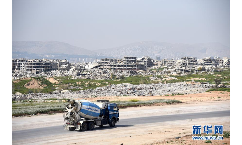 这是3月12日在叙利亚大马士革拍摄的道路旁的建筑废墟。 新华社发（胡马姆·谢赫·阿里 摄）