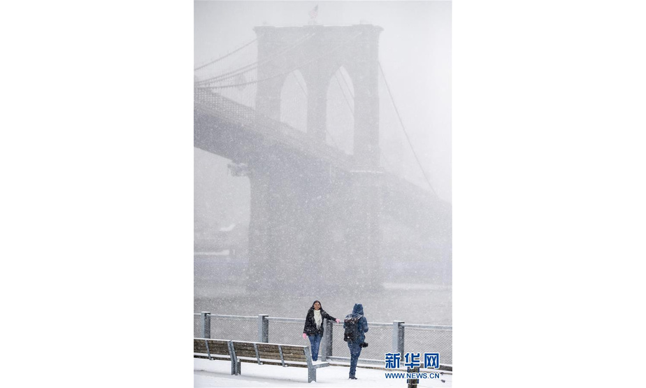 2月20日，在美国纽约布鲁克林大桥下，游客在雪中拍照。

　　当日，纽约迎来降雪天气。

　　新华社记者 王迎 摄