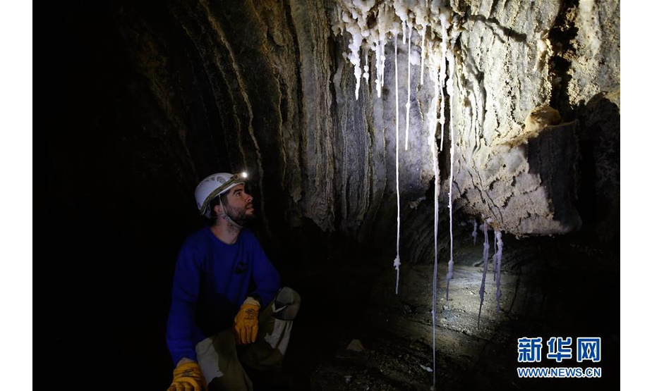 4月14日，在位于死海南端的以色列迈勒海姆盐洞内，来自希伯来大学的博阿兹·朗福德介绍盐洞情况。 以色列洞穴研究专家近日宣布，他们与来自其他国家的洞穴探索者合作勘查发现，位于死海地区的以色列迈勒海姆洞长10公里，是世界上最长的盐洞。这个盐洞最初由以色列希伯来大学洞穴研究中心专家上世纪80年代在绵延11公里的塞多姆山里发现。塞多姆山位于死海西南端，比海平面低170米。山体几乎全部由盐构成，只覆盖薄薄一层岩石。每年冬季，雨水渗入山石缝隙，溶解盐分，不断形成新的洞穴。 新华社发（吉尔·科恩·马根 摄）