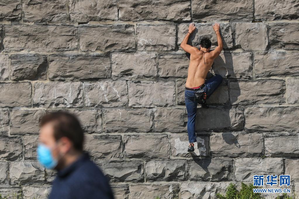 6月9日，在比利时布鲁塞尔的五十周年纪念公园，一名男子练习攀岩。

鉴于当前新冠疫情进一步缓解，比利时当天启动“夏季计划”第一阶段，餐馆、咖啡馆、酒吧等恢复室内营业。

新华社记者郑焕松摄