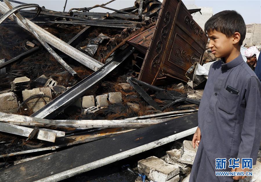 7月2月，一名男孩站在也门首都萨那一处遭空袭的仓库废墟旁。 据马西拉电视台1日报道，也门首都萨那当天多次遭战机空袭，胡塞武装称多国联军实施了空袭。 新华社发（穆罕默德摄）