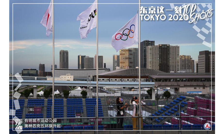 7月20日，工作人员在东京有明城市运动公园小轮车比赛场地升起奥林匹克五环旗。 新华社记者 李尕 摄 制图：宋彦桦