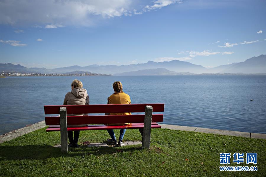 11月12日，在瑞士苏黎世，人们在湖畔享受秋日阳光。 苏黎世位于瑞士中北部，是瑞士最大城市。 新华社发（米歇尔·立米纳摄）