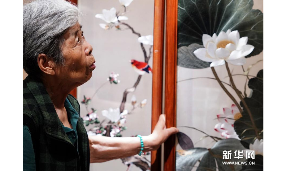 在开封市素花宋绣工艺有限公司的展示馆里，王素花在观看自己的刺绣作品（7月30日摄）。新华社记者李嘉南摄