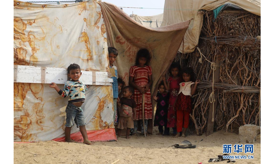 6月17日，孩子们站在也门北部哈杰省一座难民营内。

　　连续的高温天气和人道主义物资的缺乏使得也门北部哈杰省的流离失所者生活愈发艰难。也门内战爆发以来，至少500万人被迫流离失所。新华社发（阿尔瓦菲摄）