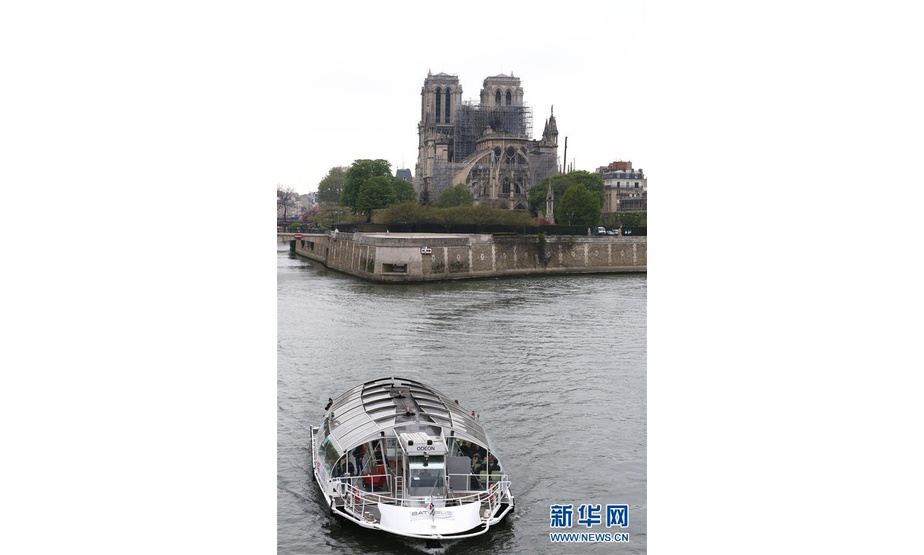 4月16日，在法国巴黎，一艘游船经过火灾后的巴黎圣母院。新华社记者高静摄