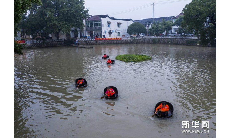 6月23日，东林镇村民在泉心村荷花池参加端午划菱桶趣味活动（无人机照片）。新华社记者 徐昱 摄