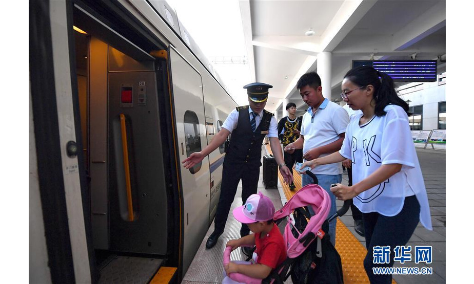 8月21日，D6622次列车乘务员在曹妃甸东站引导乘客上车。新华社记者 杨世尧 摄