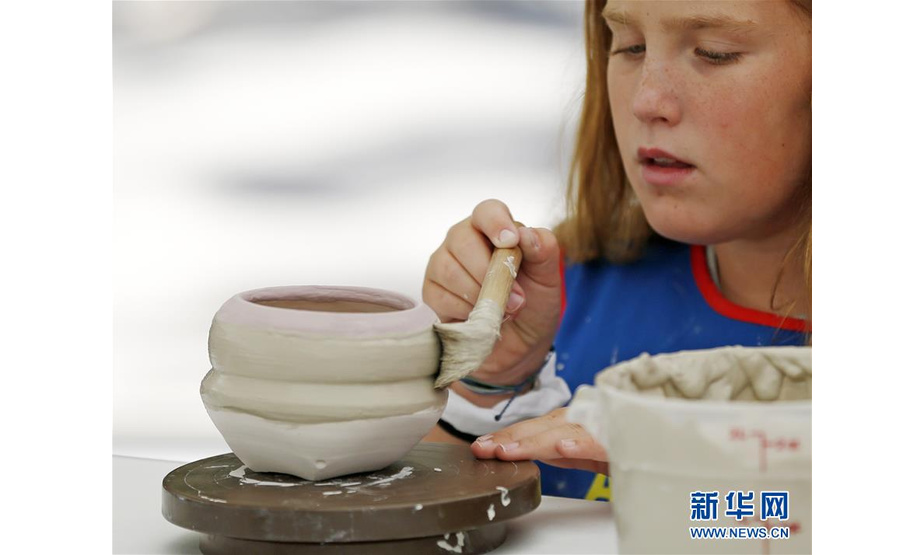 8月5日，在美国加利福尼亚州拉古纳海滩，一名女孩在艺术节上制作陶土作品。新华社记者 李颖 摄