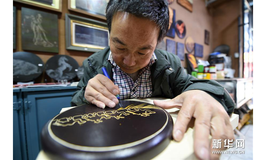 5月6日，申洪杰在敦煌市沙州市场的工作室内雕刻敦煌木刻画作品《大漠驼影》。 新华社记者范培珅摄