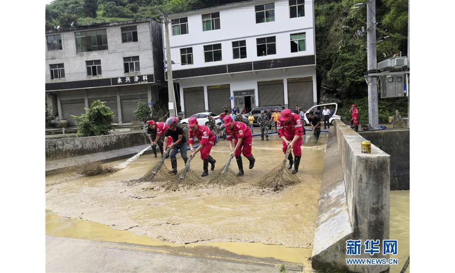 7月2日，在重庆市黔江区金溪镇金溪社区，应急救援人员在清扫淤泥。新华社发（王安彬 摄）