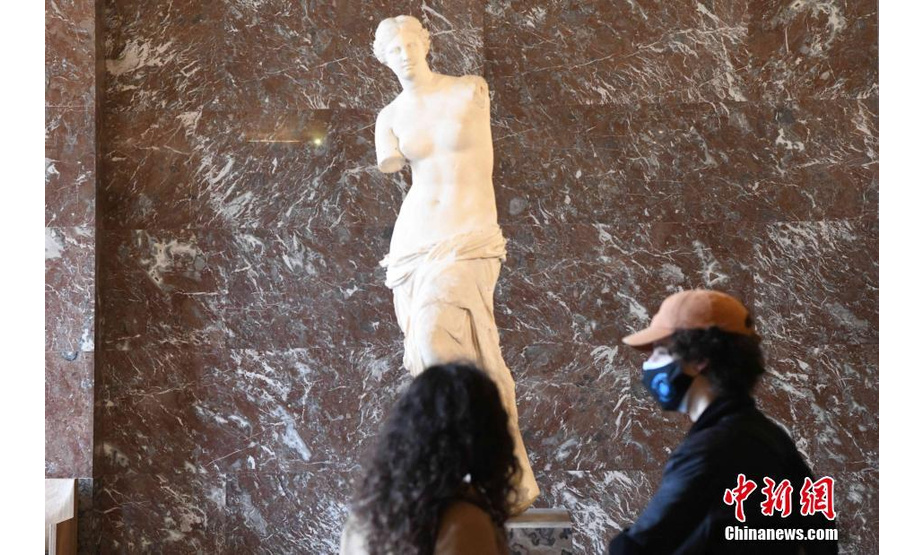 当地时间5月19日，法国巴黎卢浮宫恢复向公众开放。受疫情影响，卢浮宫等博物馆一度关闭长达半年多的时间。图为参观者欣赏雕塑《断臂维纳斯》。 中新社记者 李洋 摄