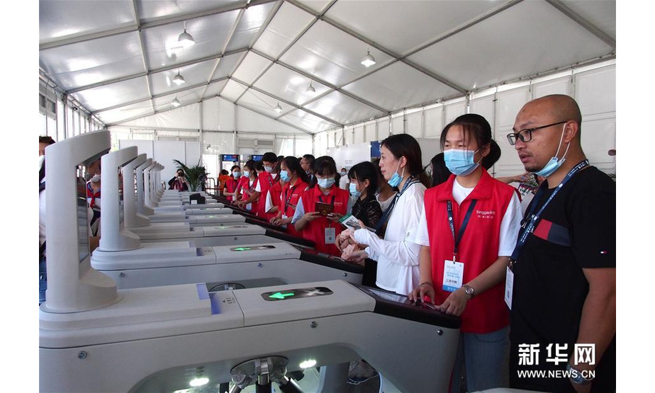 8月12日，志愿者在2020上海书展主会场入口协助读者通过实名验证入场。 新华社记者 任珑 摄