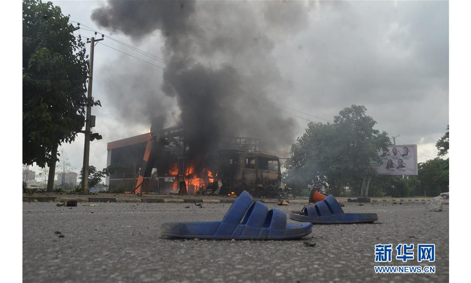 7月22日，在尼日利亚首都阿布贾，车辆在示威中被烧毁。当日，尼日利亚首都阿布贾发生示威者与警察冲突事件，至少造成1名警察死亡、1名记者受伤。新华社发（奥巴萨摄）