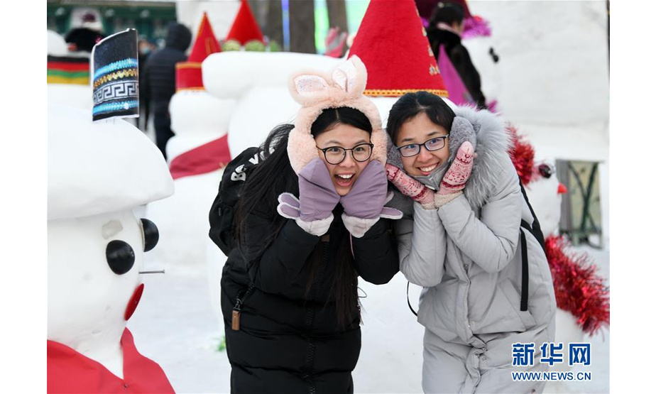 1月1日，在哈尔滨松花江畔两名女孩与雪人合影留念。

　　当日是2019年新年第一天，市民和游客在哈尔滨享受赏冰玩雪带来的快乐。

　　新华社记者王建威 摄