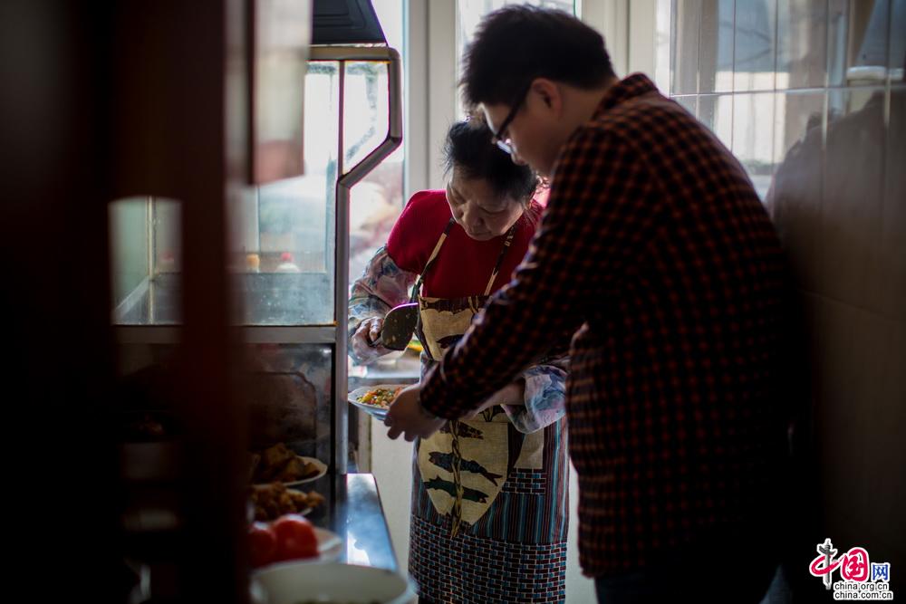 终于妈妈看不下去我做饭的“笨拙”样子“夺”去了饭铲。 “还是我来吧，你弄的话晚饭大家都吃不上了。你去看电视吧。” “一起做吧，我给您打下手……”中国网记者 郑亮 摄