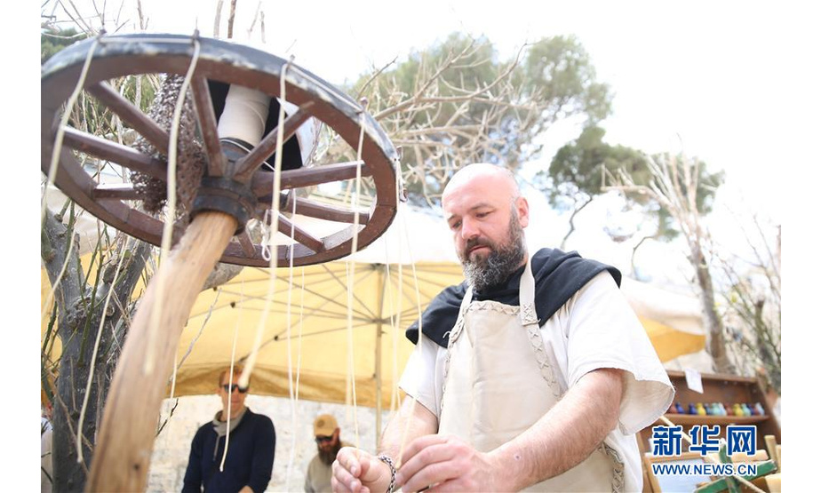 5月5日，在马耳他姆迪纳古城举行的中世纪文化节上，一名身着欧洲中世纪时期服饰的演员展示中世纪蜡烛制作方法。 新华社发（袁韵摄）