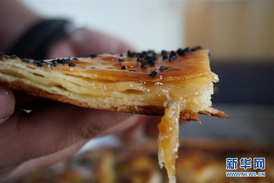 9月4日，在也门萨那，厨师展示制作完成的也门传统甜点“盘中少女”。新华社发（阿扎基摄）