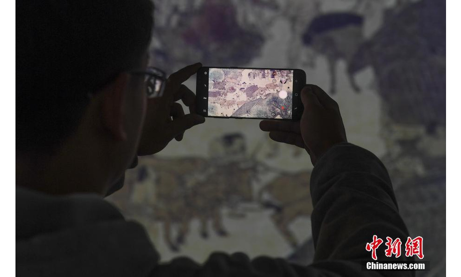 12月17日，一位市民在拍摄《清明上河图3.0》细节。近日，浙江绍兴展出《清明上河图3.0》，巨幅“活化”图景吸引民众参观。中新社记者 王刚 摄
