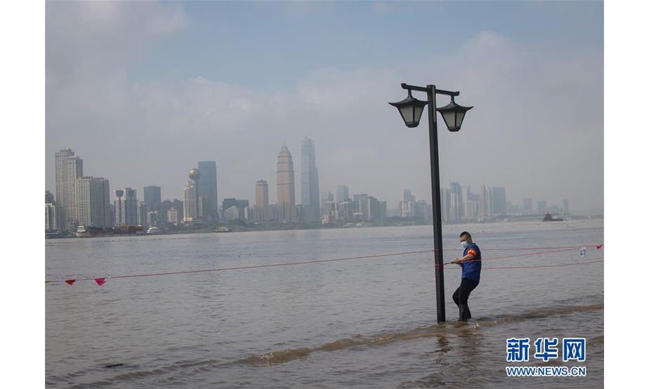 7月6日，工作人员在武昌江滩上拉警戒线。  新华社记者 肖艺九 摄
