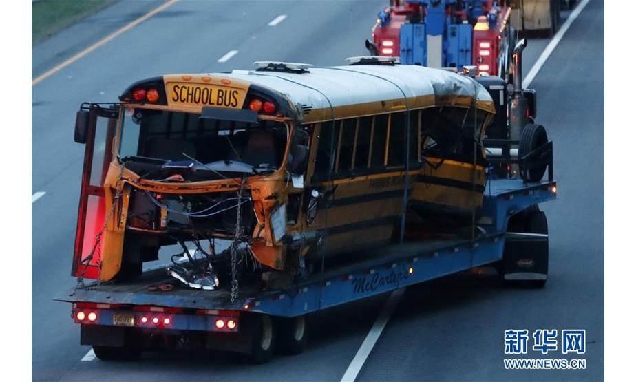 5月17日，在美国新泽西州莫里斯县，发生撞车事故的校车被运离事发地。新华社记者李木子 摄