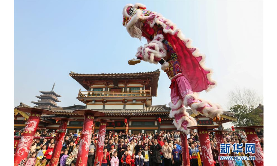 2月5日，游客在湖北省襄阳市唐城庙会上观看舞狮表演。
