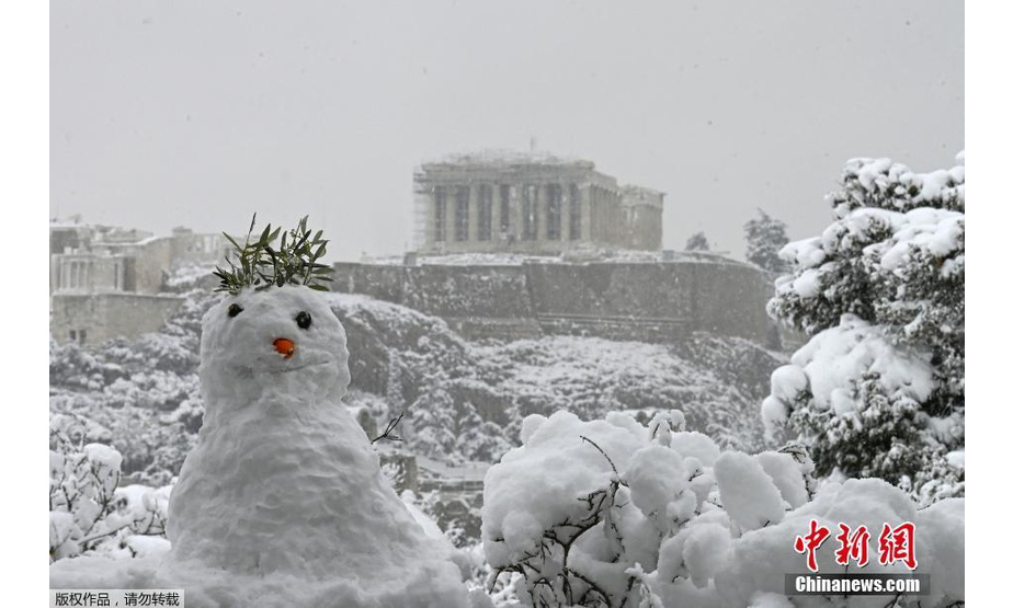 当地时间2月16日，希腊雅典迎来罕见大雪天气，古老的卫城被积雪覆盖。图为民众用积雪捏的雪人。