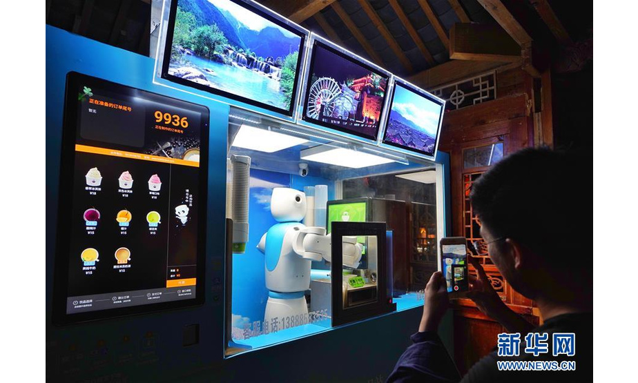 6月6日，游人在云南丽江古城体验智能机器人服务。 在夜色中的世界文化遗产云南丽江古城灯光璀璨，越夜越美丽。 新华社记者 秦晴 摄
