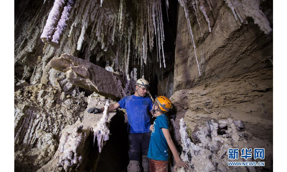 4月14日，在位于死海南端的以色列迈勒海姆盐洞内，来自以色列洞穴探索俱乐部的约阿夫·内盖夫（左）介绍盐洞情况。 以色列洞穴研究专家近日宣布，他们与来自其他国家的洞穴探索者合作勘查发现，位于死海地区的以色列迈勒海姆洞长10公里，是世界上最长的盐洞。这个盐洞最初由以色列希伯来大学洞穴研究中心专家上世纪80年代在绵延11公里的塞多姆山里发现。塞多姆山位于死海西南端，比海平面低170米。山体几乎全部由盐构成，只覆盖薄薄一层岩石。每年冬季，雨水渗入山石缝隙，溶解盐分，不断形成新的洞穴。 新华社记者 郭昱 摄