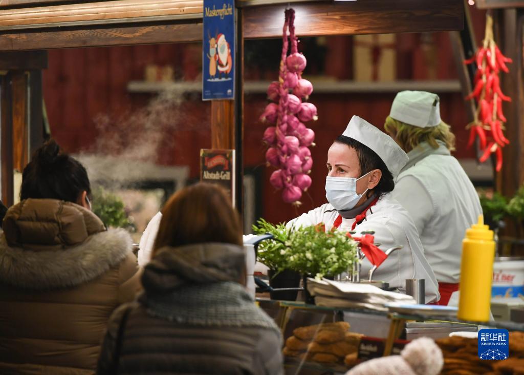 11月22日，在德国法兰克福圣诞市场，戴口罩的工作人员为顾客服务。

　　受新冠疫情影响，德国柏林、法兰克福等地的圣诞市场有的取消，有的在较为严格的防疫措施下开放。

　　新华社记者 逯阳 摄