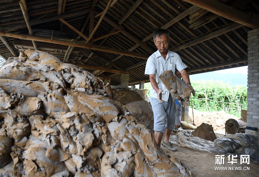 8月15日，在泾县茂林花砖厂，工人将两种不同的泥进行混合。 花砖是安徽省泾县茂林镇特有的一种古建装饰材料，主要用于门、墙、窗户的装饰。上品花砖呈青白色，不仅花纹清晰、图案雅致，而且具有手感轻柔、不沾灰的特点。明清时期，花砖开始普遍运用于茂林当地民宅中。然而，花砖制作工艺复杂，成本高，加上花砖艺人因躲避战乱流落他乡，花砖制作工艺一度失传。20世纪90年代，茂林人开始重新挖掘花砖制作工艺，逐渐恢复了花砖的生产。如今，花砖制作工艺包括取土、制坯、烧制、水磨等12道大的工序。2014年，花砖制作技艺被列为安徽省省级非物质文化遗产。 新华社记者 刘军喜 摄