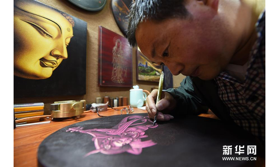 5月6日，申洪杰在敦煌市沙州市场的工作室内雕刻敦煌木刻画作品《反弹琵琶》。 新华社记者范培珅摄 