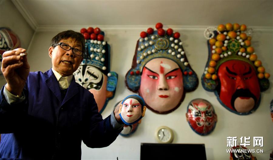4月12日，张智在家中介绍脸谱创作过程。新华社发（陈其保 摄）