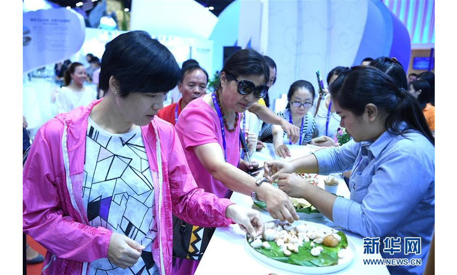 9月12日，在广西南宁国际会展中心东盟博览会展厅，观众在品尝泰国水果。 当日，第十五届中国—东盟博览会在广西南宁国际会展中心举行。 新华社记者 周华 摄