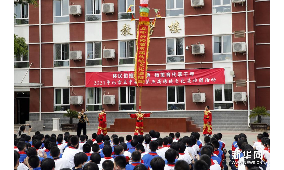 5月10日，民间艺人为学生们表演中幡。新华社发（周良 摄）